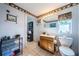 Bathroom with tile floors, wooden vanity, and framed mirror, with an open doorway to the hallway at 11831 104Th Ln, Largo, FL 33773