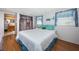 Well-lit bedroom with wood-look floors, quaint blue curtains, and a decorative bathroom doorway at 11831 104Th Ln, Largo, FL 33773