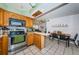 Eat-in kitchen with wood cabinetry, stainless steel appliances and tile floors at 11831 104Th Ln, Largo, FL 33773