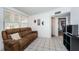 Inviting living room featuring a comfortable brown sofa and ample natural light from a large window at 11831 104Th Ln, Largo, FL 33773