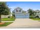 Charming two-story home showcasing a three-car garage, lush landscaping, and a well-manicured lawn at 11911 Greenchop Pl, Riverview, FL 33579