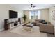 Bright living room featuring neutral walls, area rug, ceiling fan, and comfortable seating area at 11911 Greenchop Pl, Riverview, FL 33579