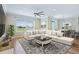 Spacious living room featuring a ceiling fan, large windows, and wood flooring at 11911 Greenchop Pl, Riverview, FL 33579