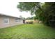 Expansive backyard featuring a well-kept lawn, a wooden fence, and exterior views of the house at 11928 Mandarin Ct, Seminole, FL 33772
