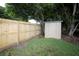 Fenced backyard featuring a storage shed, well-maintained grass, and mature trees at 11928 Mandarin Ct, Seminole, FL 33772