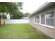 Spacious backyard featuring green grass, a privacy fence, and the exterior of the home at 11928 Mandarin Ct, Seminole, FL 33772