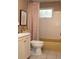 Bathroom with tub, toilet, vanity and a window at 11928 Mandarin Ct, Seminole, FL 33772