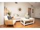 Bright living room featuring a white sofa, accent chair, decorative mirror, and stylish coffee table at 11928 Mandarin Ct, Seminole, FL 33772