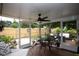 A screened-in patio featuring a ceiling fan, table, and chairs offering a serene outdoor living space at 11928 Mandarin Ct, Seminole, FL 33772