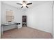 Bright bedroom featuring neutral carpet, a ceiling fan, and a desk with a shelving unit at 12107 Nouveau Ave, Spring Hill, FL 34610