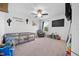 Well-lit bedroom with neutral carpet, ceiling fan, and personalized wall decorations at 12107 Nouveau Ave, Spring Hill, FL 34610