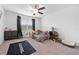 Bright bedroom with carpet features a cozy bed, ceiling fan, and natural light at 12107 Nouveau Ave, Spring Hill, FL 34610