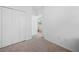 A neutral-carpeted bedroom has a closet, leading to a bathroom at 12107 Nouveau Ave, Spring Hill, FL 34610