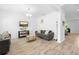 Bright living room boasting ample seating, stylish decor, and wood-look ceramic tile at 12107 Nouveau Ave, Spring Hill, FL 34610