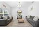 Well-lit living room featuring comfortable sofas, modern decor, and wood-look ceramic tile at 12107 Nouveau Ave, Spring Hill, FL 34610