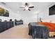 Bright main bedroom with carpet, features a cozy bed, crib, dresser, ceiling fan, and a wall-mounted television at 12107 Nouveau Ave, Spring Hill, FL 34610