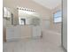 Bright bathroom offers double sinks, large mirror, tub, and shower at 12653 Longcrest Dr, Riverview, FL 33579