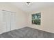 This bedroom features a ceiling fan, a large window, and a closet with folding doors at 12653 Longcrest Dr, Riverview, FL 33579