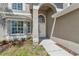 Front entrance featuring a tiled walkway, neat mulch beds, and a modern white door at 12653 Longcrest Dr, Riverview, FL 33579