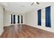 Living room featuring wood flooring and multiple windows with dark drapes at 12653 Longcrest Dr, Riverview, FL 33579
