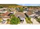 Aerial view of a home nestled in a residential neighborhood with lush greenery and nearby mountain views at 14434 Scottburgh Glen Dr, Wimauma, FL 33598