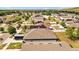 Aerial view of a home nestled in a residential neighborhood with lush greenery and white privacy fences at 14434 Scottburgh Glen Dr, Wimauma, FL 33598