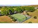 Aerial view of a fenced basketball court with benches, located in a green space surrounded by trees at 14434 Scottburgh Glen Dr, Wimauma, FL 33598