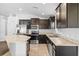 Well-equipped kitchen with granite countertops, stainless steel appliances, and dark wood cabinetry at 14434 Scottburgh Glen Dr, Wimauma, FL 33598