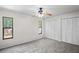 Bright bedroom features neutral carpet, ceiling fan, and double windows for natural light at 16139 Villa Dr, Hudson, FL 34667