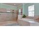 Bright bathroom featuring a soaking tub, glass-enclosed shower with tiled walls, and modern fixtures at 16612 5Th E Ave, Bradenton, FL 34212