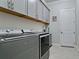 Well-organized laundry room featuring gray cabinets and modern Maytag washer and dryer at 16612 5Th E Ave, Bradenton, FL 34212