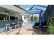 View of the outdoor bar with barstool seating, lounge chairs, and a fan overhead at 16612 5Th E Ave, Bradenton, FL 34212