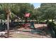 Community playground with swings, slide, jungle gym, and shade structure in a fenced-in area at 16612 5Th E Ave, Bradenton, FL 34212