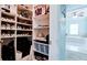 Organized walk-in closet featuring ample shelving for shoes, luggage, and accessories with access to the bright bathroom at 16612 5Th E Ave, Bradenton, FL 34212