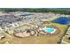 High angle view of a community recreation area featuring a playground, pool, and gathering areas in a well-maintained green space at 16633 Sunburst Lake S St, Wimauma, FL 33598