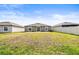 Wide backyard with green grass between neighboring houses and a sliding glass door at 16633 Sunburst Lake S St, Wimauma, FL 33598
