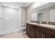 Bathroom boasts tiled shower, dual sinks with granite countertop, and vanity at 16633 Sunburst Lake S St, Wimauma, FL 33598