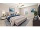 Well-lit bedroom with a bench, wall art, ceiling fan, and soft neutral carpet at 16633 Sunburst Lake S St, Wimauma, FL 33598