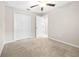 This bedroom features carpet flooring, a ceiling fan, and a closet for storage at 16633 Sunburst Lake S St, Wimauma, FL 33598