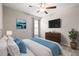 Comfortable bedroom with ceiling fan, a dresser, side table, artwork, and soft carpeting at 16633 Sunburst Lake S St, Wimauma, FL 33598