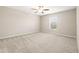 This bedroom features neutral walls, carpet, a ceiling fan, and a window for natural light at 16633 Sunburst Lake S St, Wimauma, FL 33598