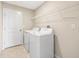 Laundry room equipped with washer, dryer, tiled floor, and ample shelving at 16633 Sunburst Lake S St, Wimauma, FL 33598