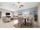 Combined living room and dining room with a ceiling fan and multiple windows providing lots of natural light at 16633 Sunburst Lake S St, Wimauma, FL 33598