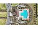 Aerial view of the community pool featuring lounge chairs and meticulously landscaped grounds for relaxation at 16633 Sunburst Lake S St, Wimauma, FL 33598