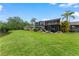Expansive backyard with lush green lawn, screened lanai, and picturesque pond views, ideal for outdoor living at 170 Ingrid Pl, Oldsmar, FL 34677