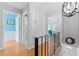 Bright hallway features wood floors, contrasting black railing, and a modern chandelier at 170 Ingrid Pl, Oldsmar, FL 34677