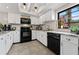 Modern kitchen with white cabinets, granite countertops, black appliances, and plenty of natural light at 170 Ingrid Pl, Oldsmar, FL 34677