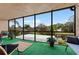 Enclosed lanai featuring a view of the pond and manicured lawn at 170 Ingrid Pl, Oldsmar, FL 34677