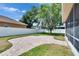 Lush backyard featuring a brick paver patio area, mature trees, and a privacy fence at 1742 Oakwood Estates Dr, Plant City, FL 33563