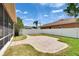 This backyard features a brown house with white fence, green grass, and a brick patio at 1742 Oakwood Estates Dr, Plant City, FL 33563